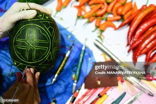 Vietnamese participant Pham Van Dong carves patterns into a watermelon during a fruit and vegetable carving competition at the 26th Thailand...