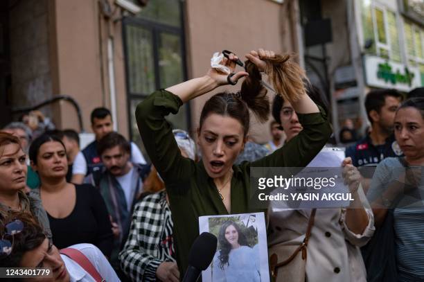 Nasibe Samsaei, an Iranian woman living in Turkey, cuts her ponytail off during a protest outside the Iranian consulate in Istanbul on September 21...