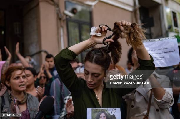 Nasibe Samsaei, an Iranian woman living in Turkey, cuts her ponytail off during a protest outside the Iranian consulate in Istanbul on September 21...