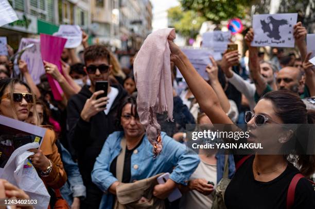 An Iranian woman living in Turkey, holds a scarf which can be used as a headscarf, during a protest outside the Iranian consulate in Istanbul on...