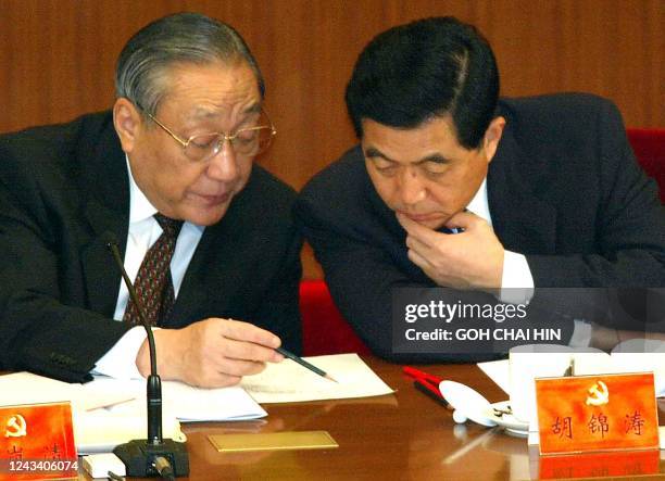 Chinese Vice President Hu Jintao consults with Vice Premier Li Lanqing during the opening session of the 16th Communist Party Congress in the Great...