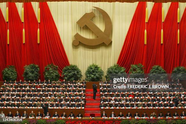 Delegates and China's top leaders beneath a Communist hammer and sickle emblem, 08 November 2002 at the Great Hall of the People in Beijing, attend...