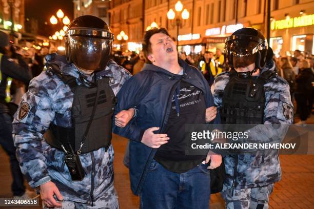 Police officers detain a man in Moscow on September 21 following calls to protest against partial mobilisation announced by President Vladimir Putin....