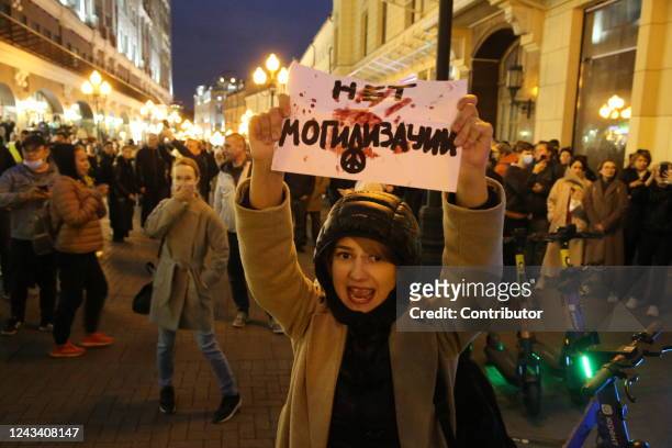 Female activist holding anti-mobilization poster shouts slogan during an unsanctioned protest rally at Arbat street, on September 21 in Moscow,...