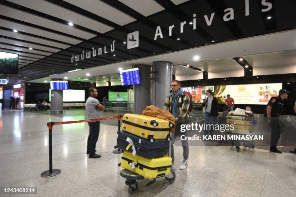 Russians arrive at Yerevan's Zvartnots airport on September 21, 2022. - Flights out of Russia were nearly fully booked this week, airline and travel...