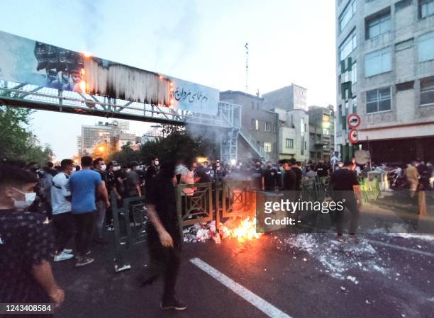 Picture obtained by AFP outside Iran on September 21 shows Iranian demonstrators burning a rubbish bin in the capital Tehran during a protest for...