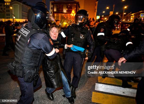 Police officers detain a woman following calls to protest against partial mobilisation announced by Russian President, in Moscow, on September 21,...
