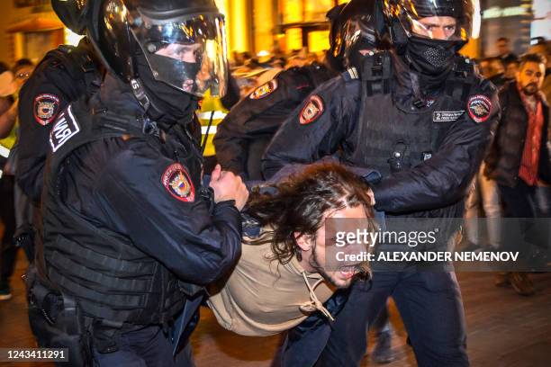 Police officers detain a man following calls to protest against partial mobilisation announced by Russian President, in Moscow, on September 21,...