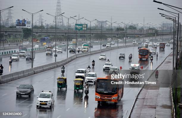 Commuters out in the rain on NH 24, on September 21, 2022 in New Delhi, India. Sudden change in meteorological conditions led to light rain in Delhi...