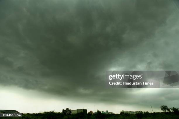 Dark clouds hover over a field on a rainy day on September 21, 2022 in Noida, India. Sudden change in meteorological conditions led to light rain in...
