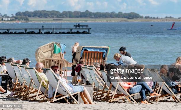 September 2022, Schleswig-Holstein, Burgtiefe Fehmarn: Tourists enjoy a sunny autumn day in their deck chairs on the southern beach of Fehmarn....