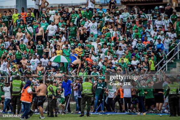 Fans of Colombia's Deportivo Cali invade the field and try to attack players and staff members of their team during the Colombian league football...