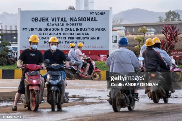 This picture taken on 21 September, 2022 shows employees on motorcycles outside the Virtue Dragon Nickel Industry nickel smelting facility in Konawe,...