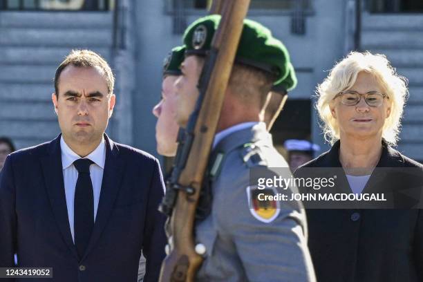 German Defence Minister Christine Lambrecht and her new French counterpart Sebastien Lecornu review an honour guard that is marching past them during...