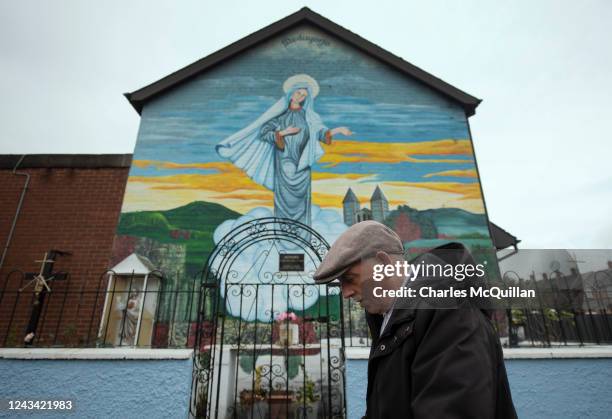 Man walks past a Catholic religious mural on the day that the Northern Ireland census was released on September 22, 2022 in Belfast, Northern...