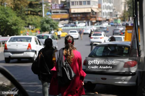 People are seen walking on the street during the day while taking to the streets in the evening to protest after the brutal death of a 22-year-old...