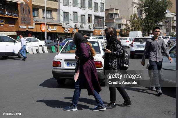 People are seen walking on the street during the day while taking to the streets in the evening to protest after the brutal death of a 22-year-old...
