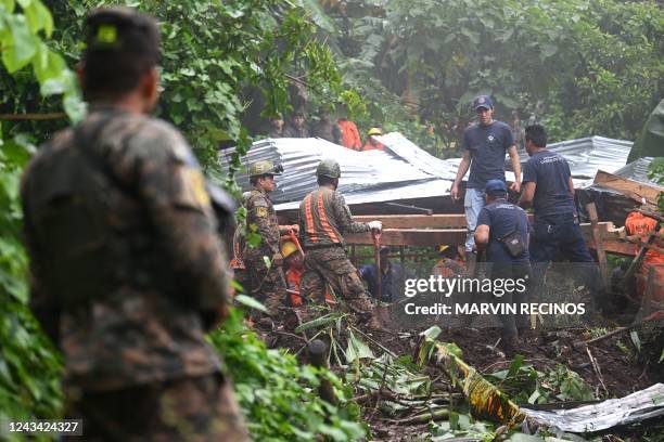Salvadorian soldiers and rescuers try to recover the bodies of five people who died after a landslide in Huizucar, El Salvador, on September 22,...