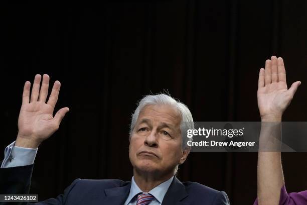 JPMorgan Chase & Co CEO Jamie Dimon raises his hand while responding to a question during a Senate Banking, Housing, and Urban Affairs Committee...
