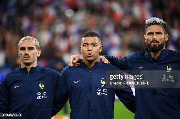 France's forward Antoine Griezmann, France's forward Kylian Mbappe and France's forward Olivier Giroud stand for the national anthem ahead of the...