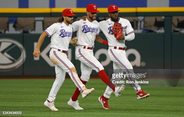 Josh Smith of the Texas Rangers, Leody Taveras and Adolis Garcia celebrate the teams 5-3 win over the Los Angeles Angels at Globe Life Field on...