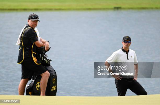 Adam Scott of Australia and the International Team with his caddie Greg Hearmon on the 11th hole during the Thursday foursome matches during the...