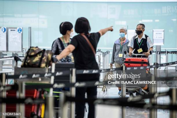 Travellers arrive at Hong Kong International Airport before making their way to hotel quarantine on September 23, 2022. - Hong Kong announced on...