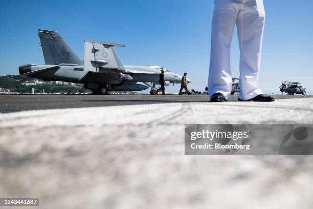 Members of the US Navy stand on board the USS Ronald Reagan, a Nimitz-class aircraft carrier and part of the US Navy 7th Fleet, anchored in Busan,...