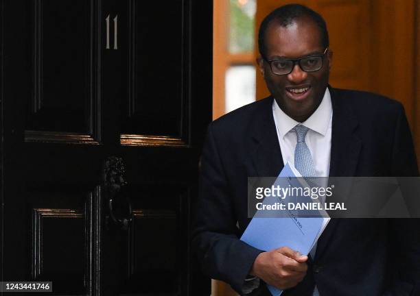 Britain's Chancellor of the Exchequer Kwasi Kwarteng holds a folder reading "The Growth Plan 2022" as he walks out of Number 11 Downing Street on his...