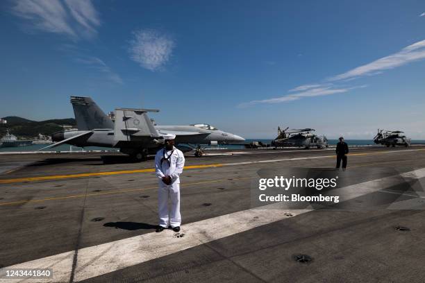 Member of the US Navy stands on board the USS Ronald Reagan, a Nimitz-class aircraft carrier and part of the US Navy 7th Fleet, anchored in Busan,...