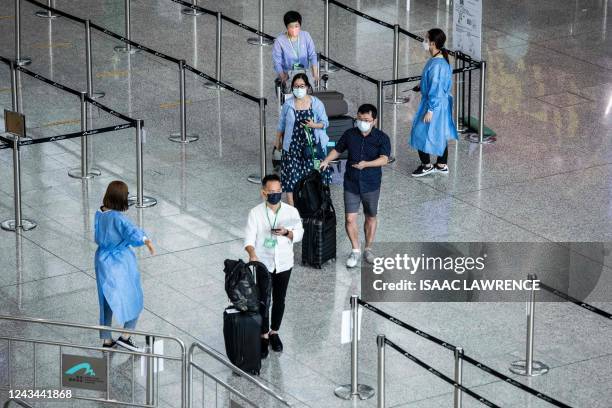 Travellers arrive at Hong Kong International Airport before making their way to hotel quarantine on September 23, 2022. - Hong Kong announced on...