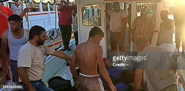 The bodies of drowning victims are loaded onto a boat in Syria's southern port city of Tartus on September 22 after a boat carrying migrants from...
