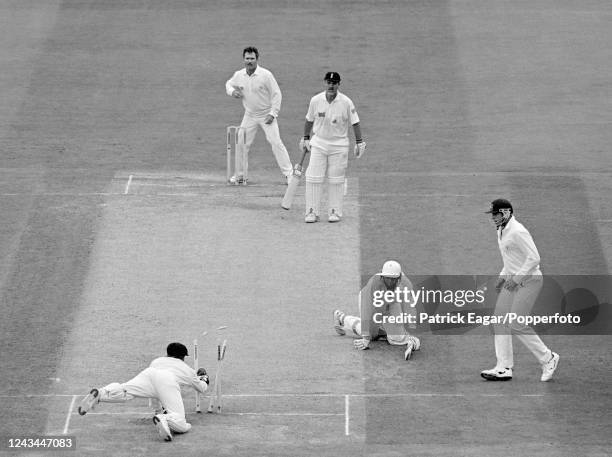 Michael Atherton of England slips after being sent back going for a third run and is is run out for 99 runs by Australia's wicketkeeper Ian Healy as...