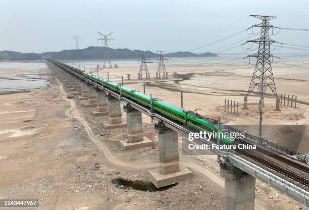 Bullet train runs on a railway bridge across the dried Poyang Lake in Hukou county, where the China's largest freshwater lake meets the Yangtze...