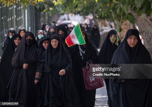 An Iranian veiled woman carrying an Irans flag while arriving the University of Tehran to take part Friday prayers ceremonies before a pro-government...