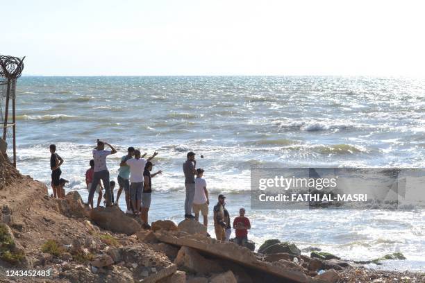 Lebanese men look towards the sea near the Arida Border Crossing with Syria, on September 23 as relatives wait for the arrival of the bodies of those...