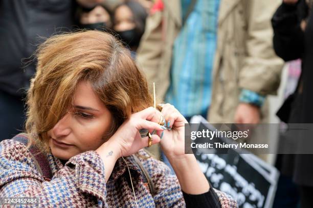 Woman cuts her hairs as a sign of protest. About 100 persons, mainly women, demonstrate on the Avenue Franklin Roosvelt, in front of the Iranian...