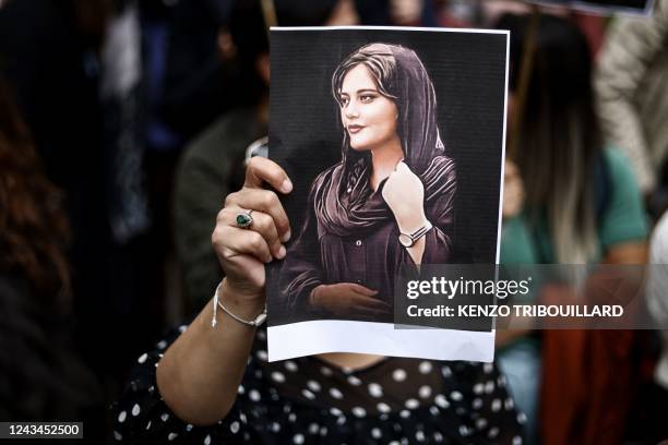 Protester holds a portrait of Mahsa Amini during a demonstration in her support in front of the Iranian embassy in Brussels on September 23 following...