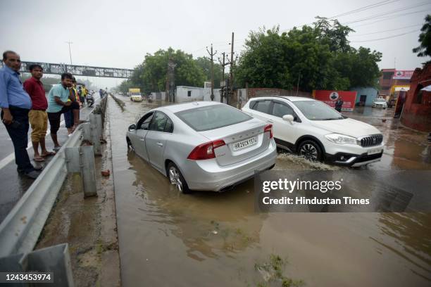 Car got stuck on a waterlogged road in heavy rain on NH-48 near the footover bridge, in Narshingpur village, on September 23, 2022 in Gurugram,...