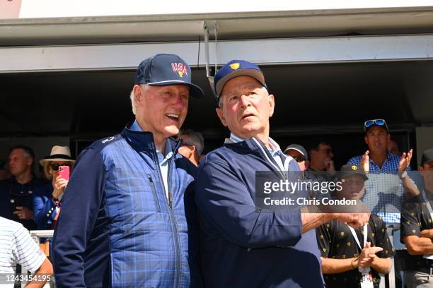 Former Presidents Bill Clinton, L, and George W. Bush watch the golf action on the first tee during the first round of Presidents Cup at Quail Hollow...