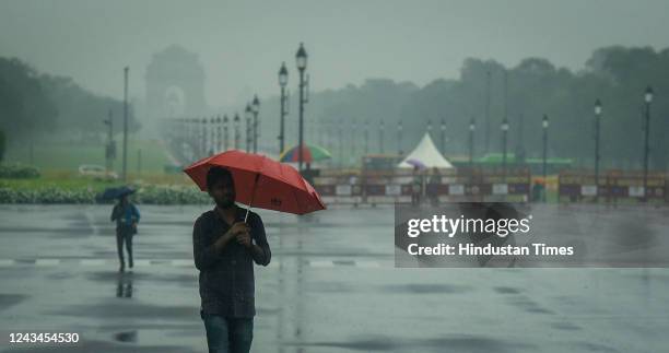 Commuters out in the rain on Kartavya Path, on September 23, 2022 in New Delhi, India. Parts of Delhi and the National Capital Region were...