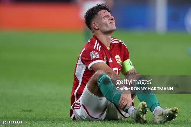 Hungary's midfielder Dominik Szoboszlai holds his leg after sustaining an injury during the UEFA Nations League football match between Germany and...