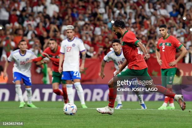 Morocco's forward Sofiane Boufal shoots a penalty kick and scores the opening goal during the international friendly football match between Chile and...
