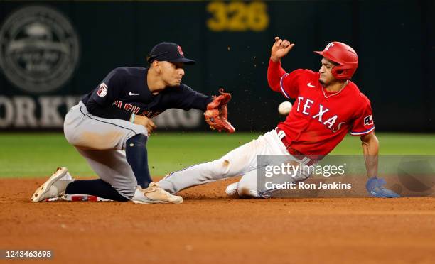 Bubba Thompson of the Texas Rangers steals second base as Andres Gimenez of the Cleveland Guardians waits for the throw during the fifth inning at...