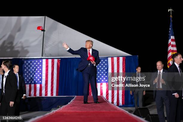 Former President Donald Trump throws MAGA hats at a Save America Rally at the Aero Center Wilmington on September 23, 2022 in Wilmington, North...