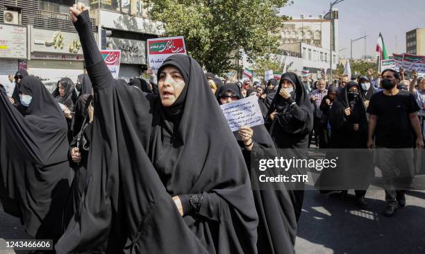 Women and men chant slogans as they march in a pro-hijab rally in Iran's capital Tehran on September 23, 2022. - Thousands of people marched through...