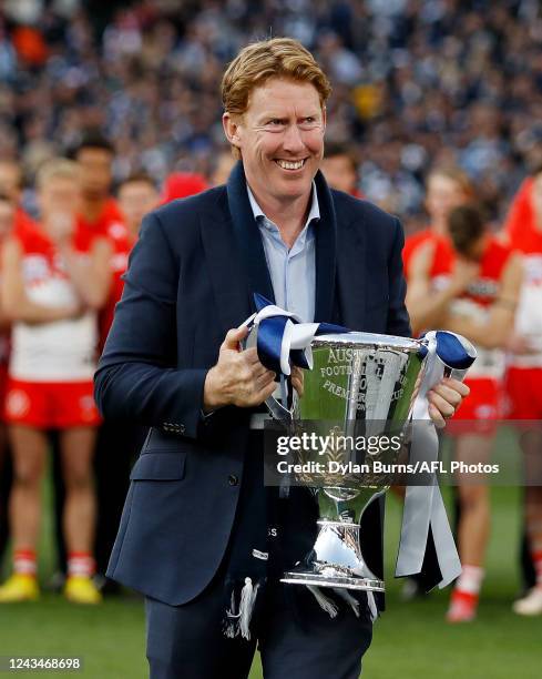 Geelong legend Cameron Ling picks up the premiership cup to deliver it to Chris Scott, Senior Coach of the Cats and Joel Selwood of the Cats during...