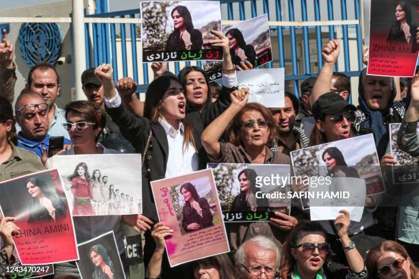 Women chant slogans and hold up signs depicting the image of 22-year-old Mahsa Amini, who died while in the custody of Iranian authorities, during a...