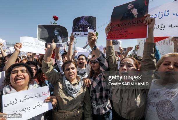 Women chant slogans and hold up signs depicting the image of 22-year-old Mahsa Amini, who died while in the custody of Iranian authorities, during a...