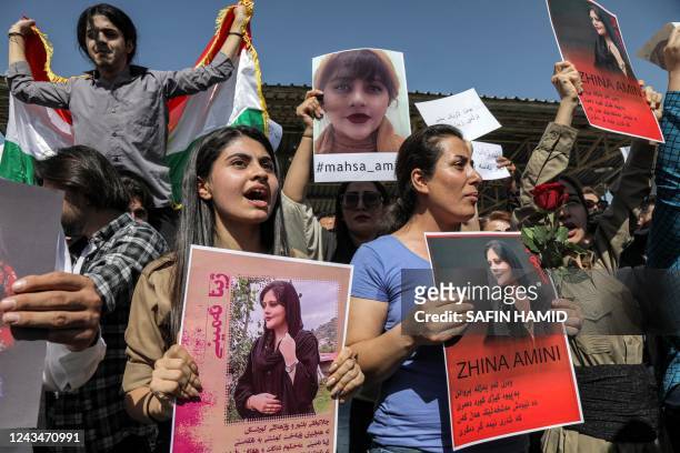 Women chant slogans and hold up signs depicting the image of 22-year-old Mahsa Amini, who died while in the custody of Iranian authorities, during a...
